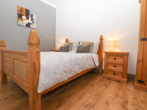 a bedroom with a wooden bed and a night stand at The Old Dairy in Herne Bay