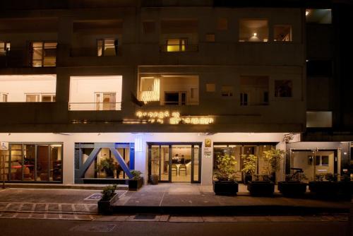 an apartment building at night with the front door illuminated at Papersun Hotel in Taipei