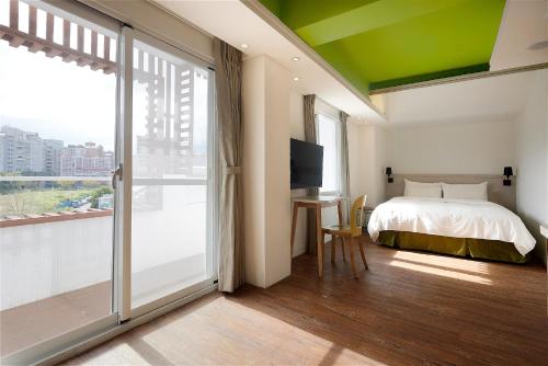 een slaapkamer met een bed en een glazen schuifdeur bij Papersun Hotel in Taipei