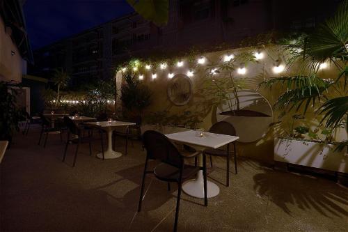 a restaurant with tables and chairs and lights on a wall at Papersun Hotel in Taipei