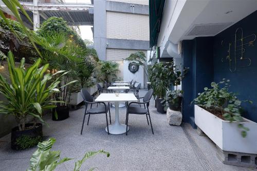 a table and chairs in a room with plants at Papersun Hotel in Taipei