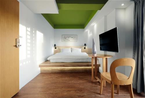 a bedroom with a bed and a table with a chair at Papersun Hotel in Taipei