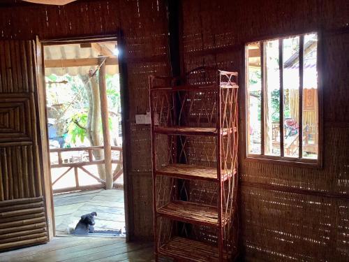 a dog sitting in a room next to a window at CocoHuts in Koh Rong Sanloem