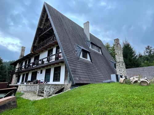 ein großes Haus mit einem Gamer-Dach auf einem Hof in der Unterkunft Cabana Serenade in Suceviţa
