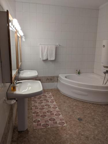 a bathroom with a tub and a toilet and a sink at Cabana Serenade in Suceviţa