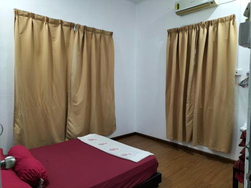 a room with a bed and a window with curtains at Che Na Homestay Pontian in Pontian Kecil