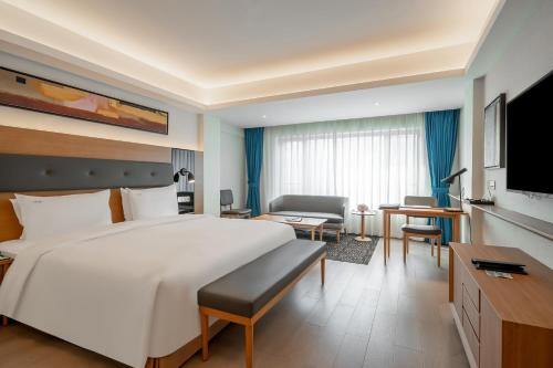 a hotel room with a large bed and a desk at Holiday Inn Shanghai Hongqiao Central by IHG in Shanghai