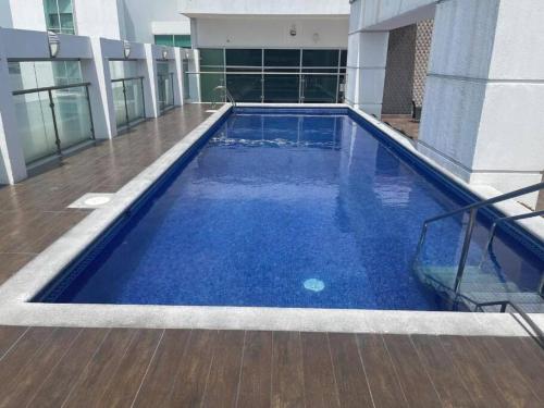 una gran piscina azul en la parte lateral de un edificio en Suite en Puerto Santana, en Guayaquil