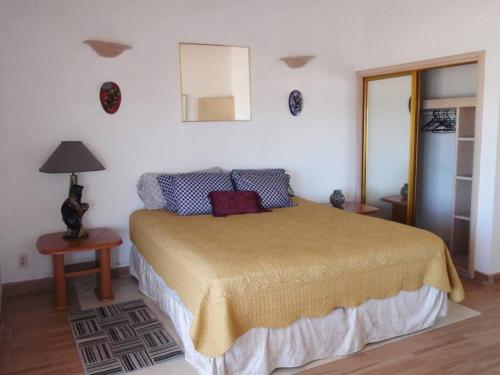 1 dormitorio con cama y espejo en la pared en Casa Blanca frente a la playa, en Playa del Estero