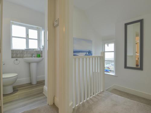 a bathroom with a sink and a toilet and a mirror at The Old Post Office in Turnchapel