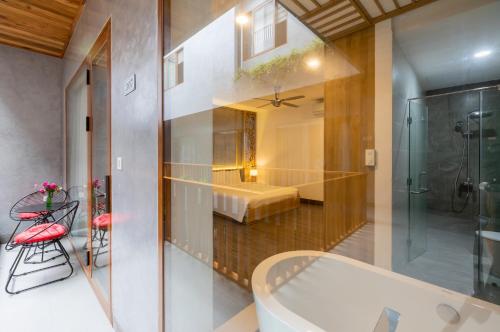 a bathroom with a bath tub and a bedroom at Moon Sun Boutique Villa Hotel in Hue