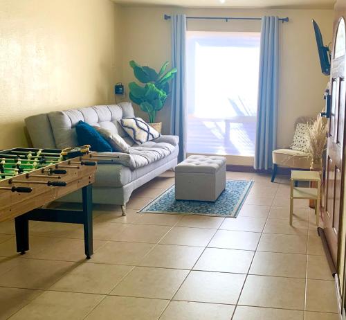 ein Wohnzimmer mit Sofa und Tischfußball in der Unterkunft Casita Capri in Ciudad Juárez
