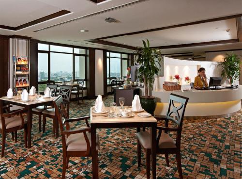 a restaurant with tables and chairs and a counter at Eastin Hotel Kuala Lumpur in Petaling Jaya