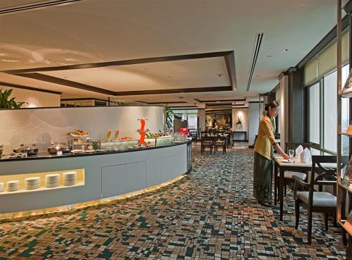 a man standing at a counter in a restaurant at Eastin Hotel Kuala Lumpur in Petaling Jaya