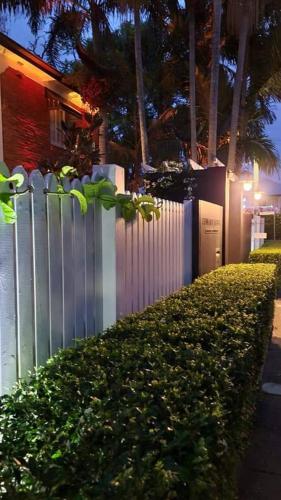 a fence with a bush next to a building at Edward Lodge New Fam in Brisbane