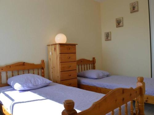 - une chambre avec 2 lits et une commode dans l'établissement Appartement climatisé 3 pièces, 6 couchages, proche plage et centre, garage inclus - FR-1-250-61, au Grau-du-Roi