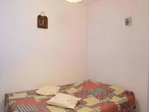 - une chambre avec un lit doté d'une couette et d'une horloge dans l'établissement Appartement climatisé 2 pièces, 4 couchages, proche Seaquarium avec parking au Grau-du-Roi - FR-1-250-74, au Grau-du-Roi