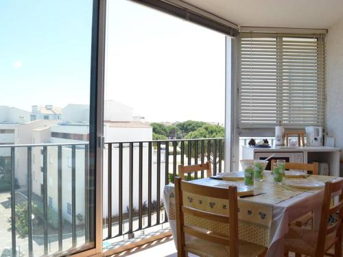 une salle à manger avec une table et un balcon dans l'établissement Appartement climatisé 2 pièces, 4 couchages, proche Seaquarium avec parking au Grau-du-Roi - FR-1-250-74, au Grau-du-Roi