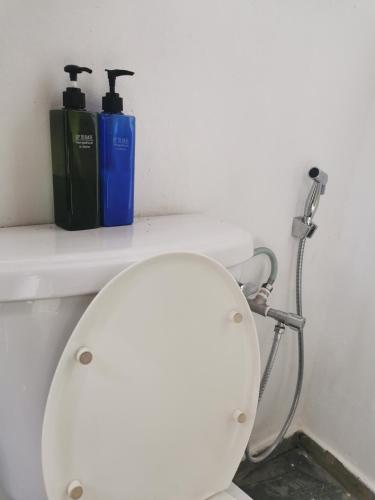 a bathroom with a toilet with two bottles on it at Coco Country Homes in Melaka