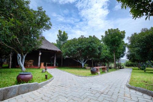a cobblestone walkway leading to a pavilion in a park at My Village - Eco Rural Resort in Coimbatore