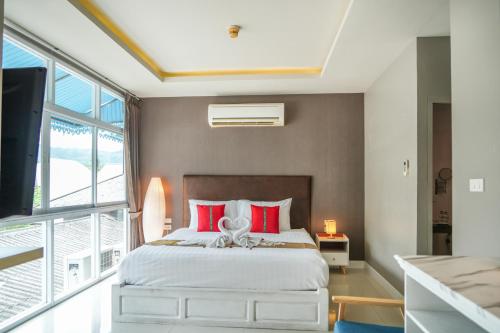 a bedroom with a large bed with red pillows at Lenny's Koh Samui in Chaweng