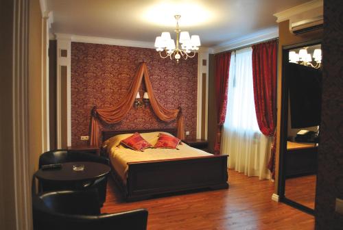 a bedroom with a bed and a table and a chandelier at Hotel Staraya Bashnya in Sarapul