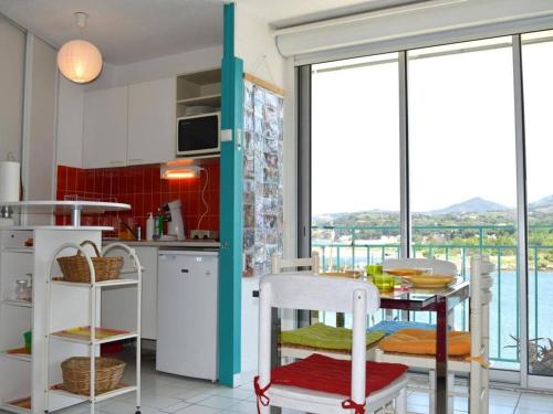 - une cuisine avec une table et une vue sur l'eau dans l'établissement Appart 2 pièces, climatisé, 150m de la mer, garage - Argelès-sur-Mer - FR-1-225-579, à Argelès-sur-Mer