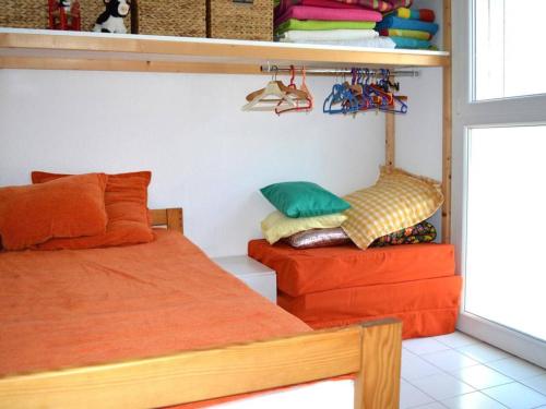 Cette chambre comprend 2 lits et une étagère avec des chaussures. dans l'établissement Appart 2 pièces, climatisé, 150m de la mer, garage - Argelès-sur-Mer - FR-1-225-579, à Argelès-sur-Mer