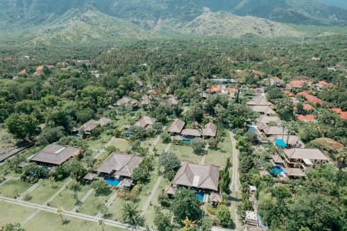an aerial view of a village with houses and mountains at Amertha Bali Villas in Pemuteran