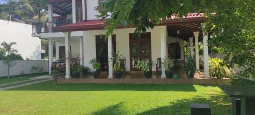 une maison avec des plantes en pot devant elle dans l'établissement Thalpitiya villa, à Wadduwa