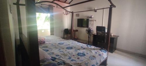 - une chambre avec un lit et une télévision dans l'établissement Thalpitiya villa, à Wadduwa