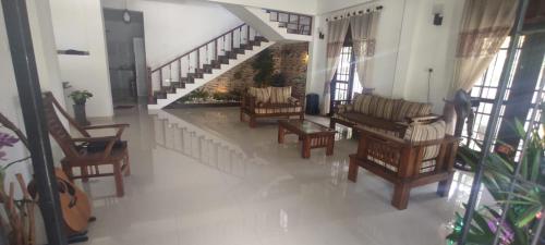 - un salon avec plusieurs chaises et un escalier dans l'établissement Thalpitiya villa, à Wadduwa