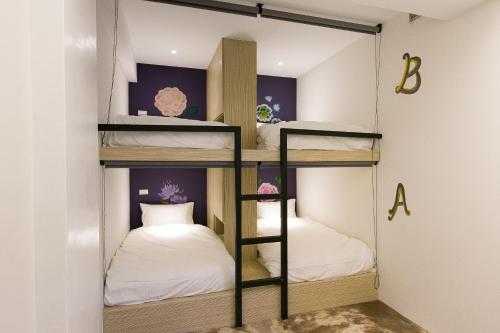 a room with three bunk beds in it at Arch Inn in Hualien City