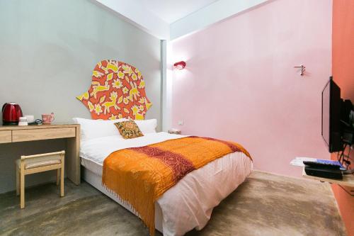 a bedroom with a bed with a colorful headboard at Arch Inn in Hualien City