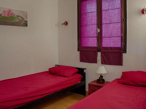 um quarto com 2 camas e uma janela com lençóis cor-de-rosa em Appartement Porticcio, 2 pièces, 4 personnes - FR-1-61-505 em Porticcio