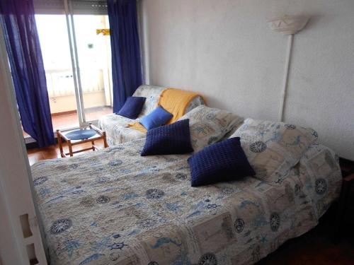 - une chambre avec un lit et un canapé avec des oreillers bleus dans l'établissement Appt climatisé 4 pers avec parking à Port Camargue - FR-1-250-206, au Grau-du-Roi