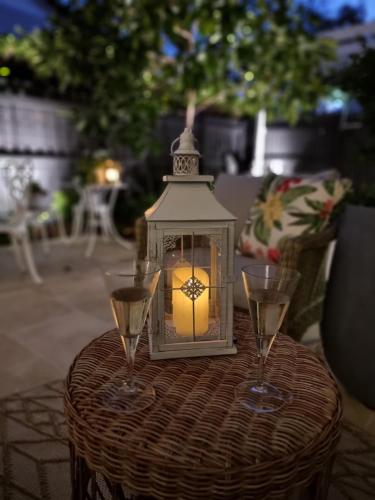 a lantern on a table with two glasses of wine at Edward Lodge New Fam in Brisbane