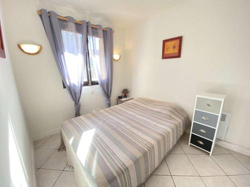 ein kleines Schlafzimmer mit einem Bett und einem Fenster in der Unterkunft Appartement Porticcio, 2 pièces, 4 personnes - FR-1-61-539 in Porticcio