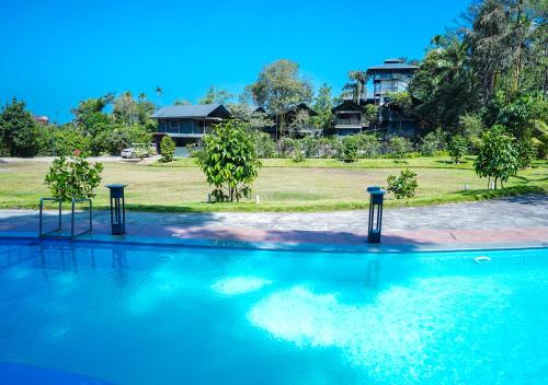 - une piscine avec deux lumières dans l'eau dans l'établissement Niyatma Wayanad Premium Coffee Resort By VOYE HOMES, à Wayanad