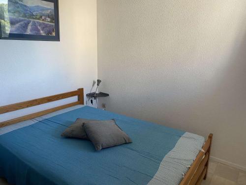 - une chambre dotée d'un lit bleu avec un oreiller dans l'établissement Appartement 2 pièces avec parking privé au Grau-du-Roi - FR-1-250-233, au Grau-du-Roi