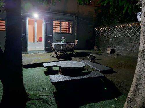a cat sitting next to a table in a yard at Appartement agréable, accès rapide. in Saint-Paul
