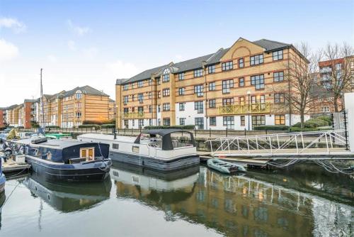 a couple of boats docked in a river with buildings at Transom Close in London