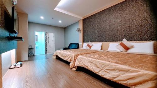 a hotel room with two beds and a chair at Chu Han C&C B&B Homestay in Madou