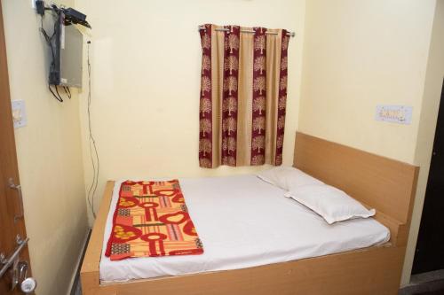 uma pequena cama num quarto com uma cortina em Ganesh Residency em Cuttack