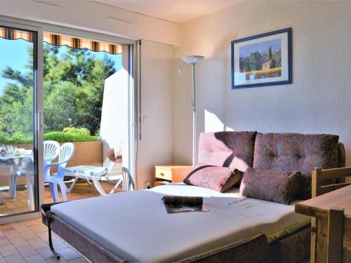 un salon avec un lit et un canapé dans l'établissement Studio coin nuit proche plage avec parking - Le Lavandou - FR-1-251-83, au Lavandou