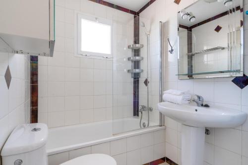 a white bathroom with a sink and a toilet at 28 Rooftop apartment close to the beach Sabinillas in San Luis de Sabinillas