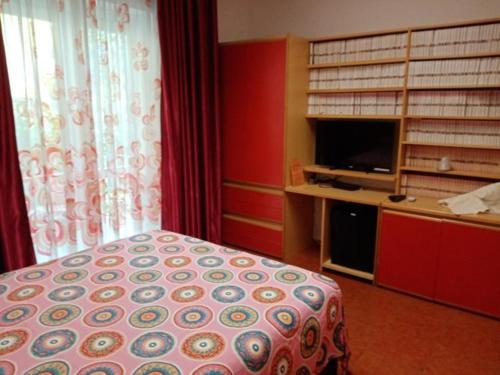 a bedroom with a bed and a tv in a room at Villa Betta in Cittadella del Capo