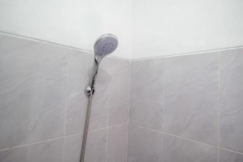 a shower with a shower head in a bathroom at KoolKost near Kampus UNS Solo (Minimum Stay 6 Nights) in Solo