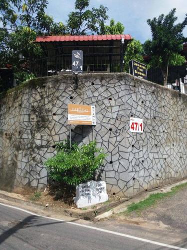 a stone wall with signs on the side of a road at New Kandy Residence in Kandy