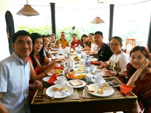 a group of people sitting at a table eating food at New Kandy Residence in Kandy